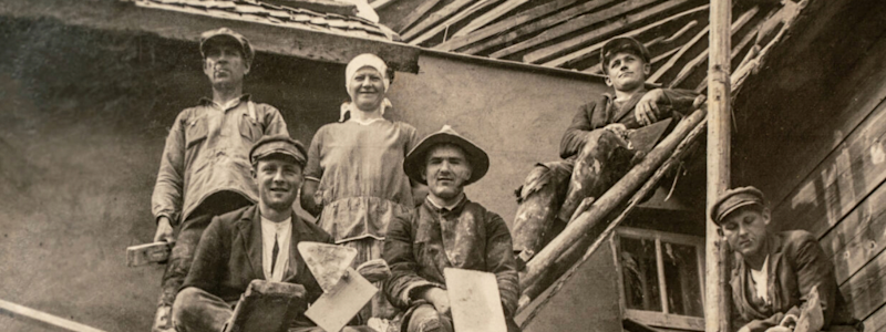 Builders sitting on scaffolding, 1920s.