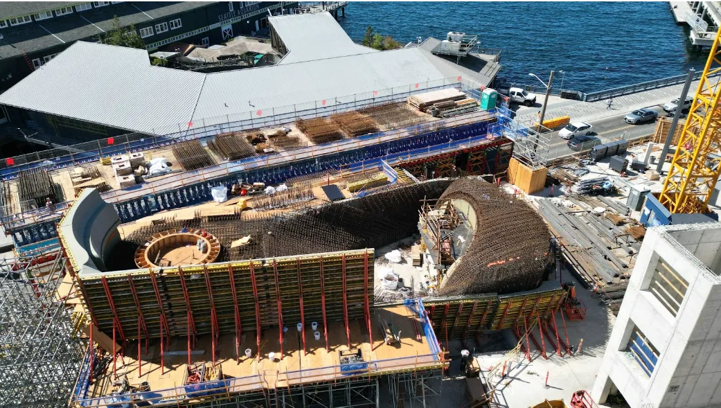 Construction site with large circular and curved structures being built.