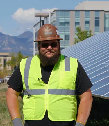 Vernon White in front of solar panels