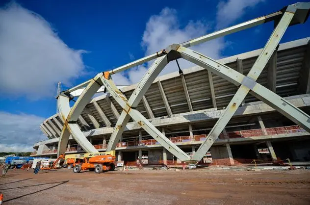 Amazonia Arena steel structure under construction with a cherry picker in the foreground.