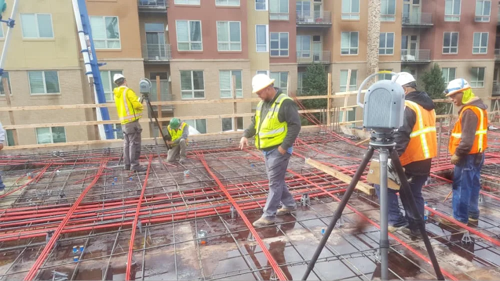 construction crew performing 3d scan with total robotic station