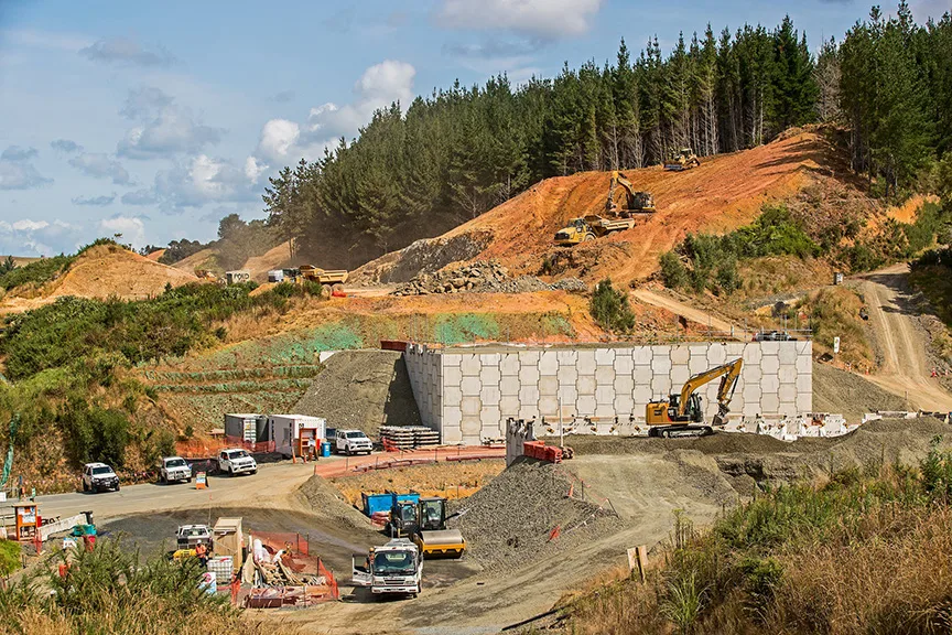 Construction site with heavy machinery and vehicles on a sunny day.