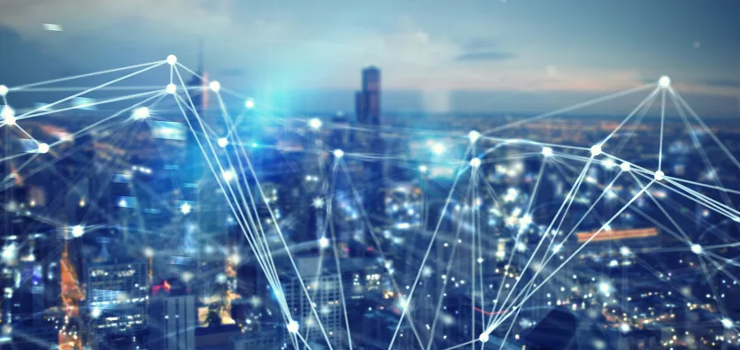 Abstract network of connections overlaid on a blurred cityscape at dusk.