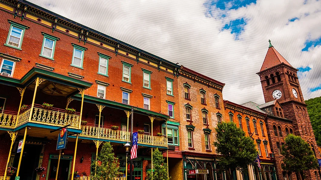 Jim Thorpe street: Victorian brick buildings, an inn with ornate green/gold balconies, and an 1893 Romanesque Courthouse with a clock tower.