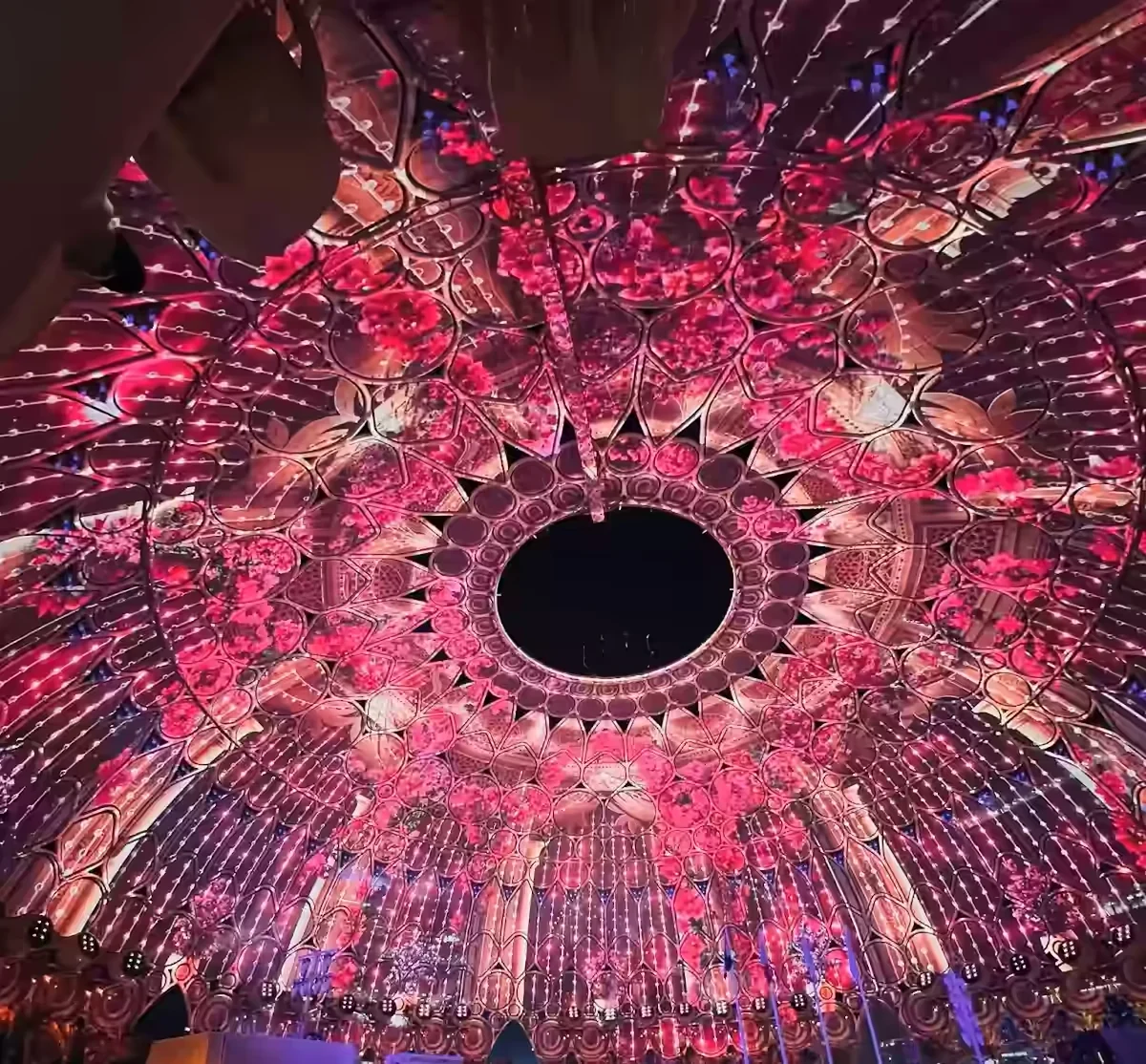 Spectacular illuminated dome interior with a crowd below.