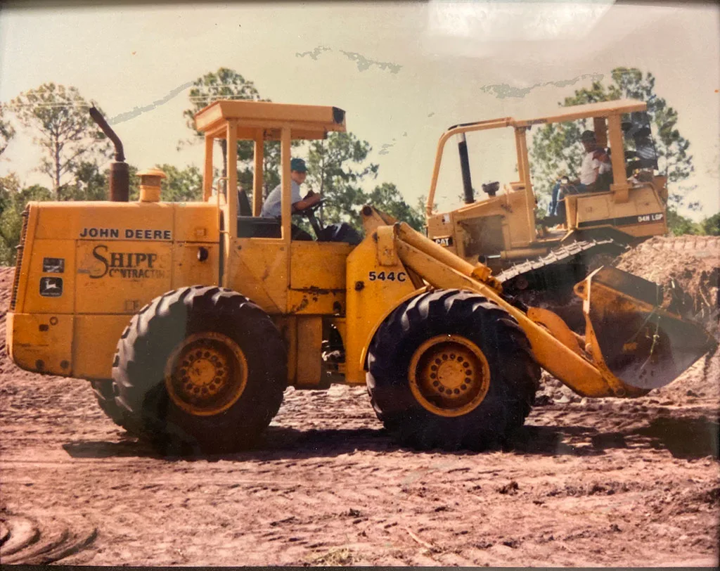 John Deere 544C wheel loader, operated by Shipp Contracts, is shown on a construction site.