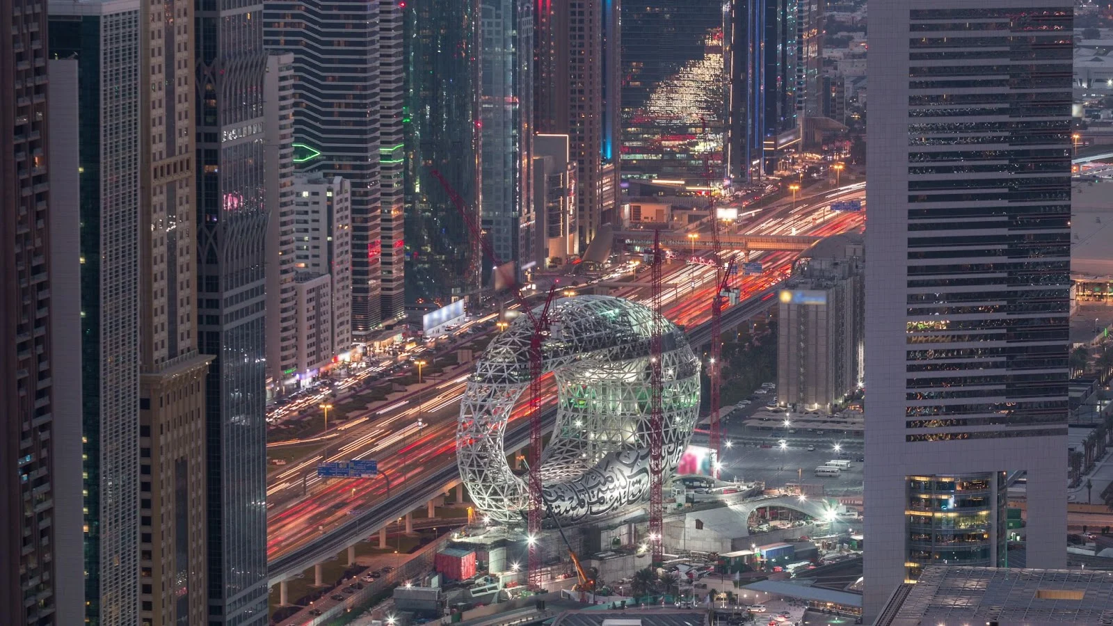 Museum of the Future in Dubai at night, with light trails from traffic on the highway.