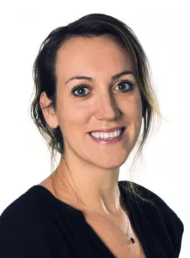 Headshot of a smiling woman with dark hair and dark eyes wearing a black top.