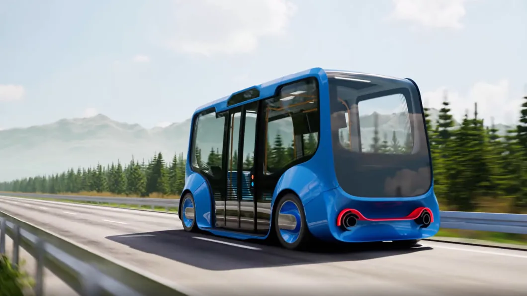 A boxy and futuristic driverless vehicle cruises along a highway through mountain pines.
