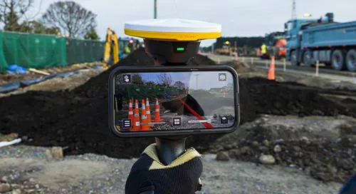 Trimble SiteVision AR device showing construction site layout overlay on a phone.