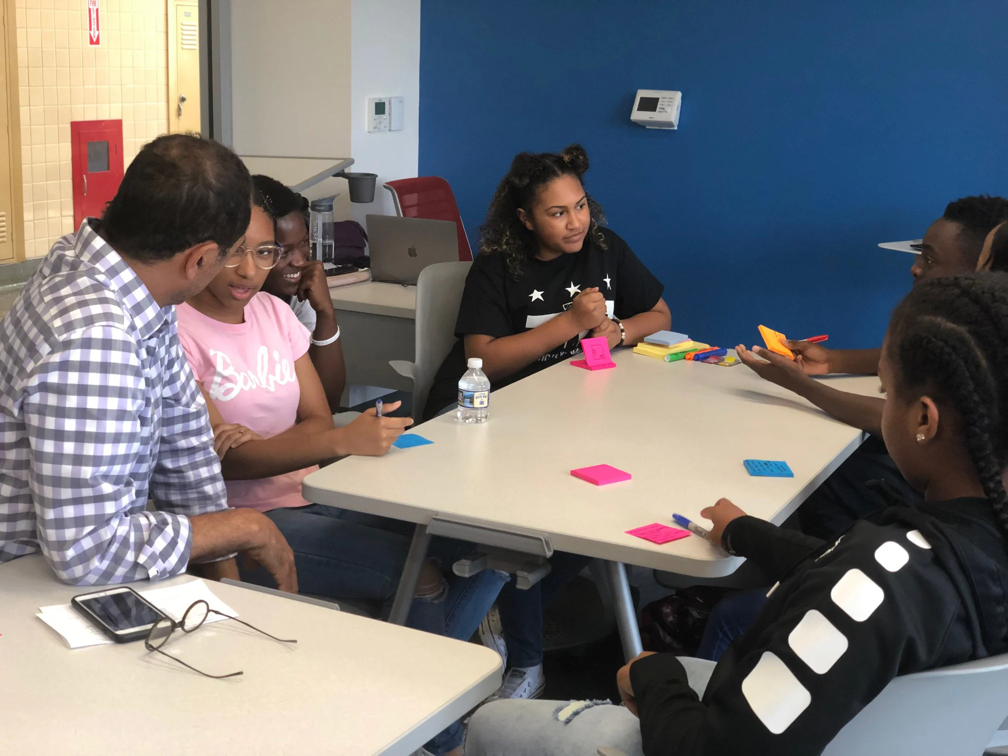 A diverse group of people of various ages engage in a brainstorming session around a table.