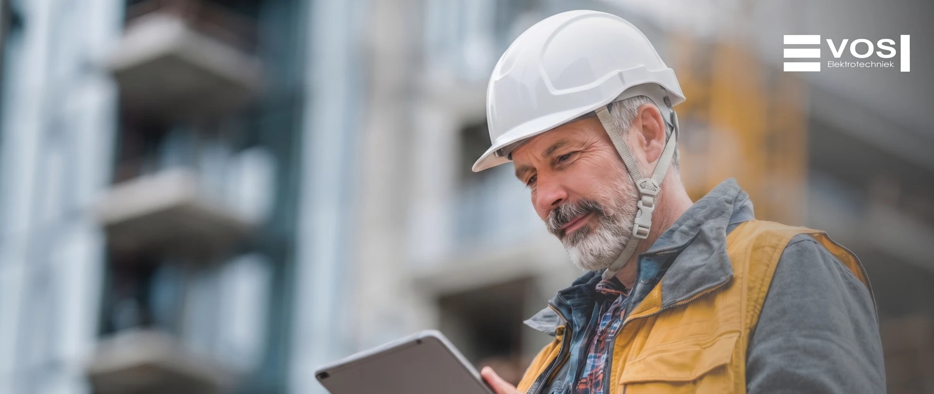 Electrical engineer wearing a white hard hat and yellow vest