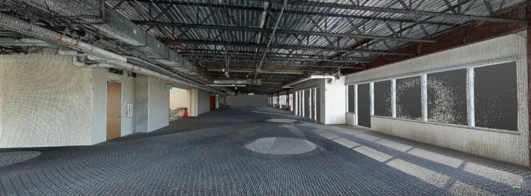 Interior view of a new construction space, showing open floor plan with exposed ceilings and large windows.