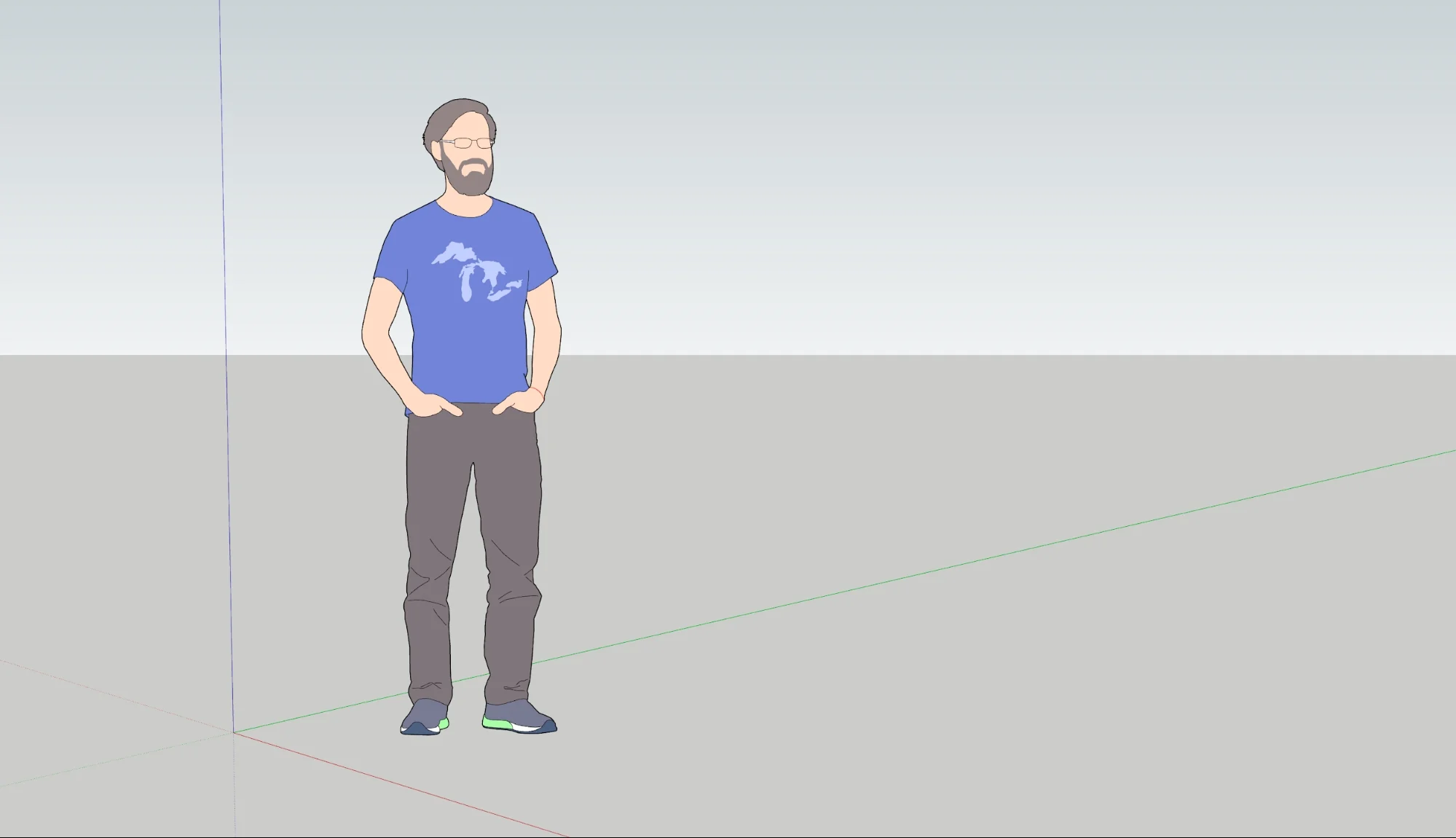 A man wearing a blue t-shirt with the Great Lakes pictured on it stands with his hands in his pockets.