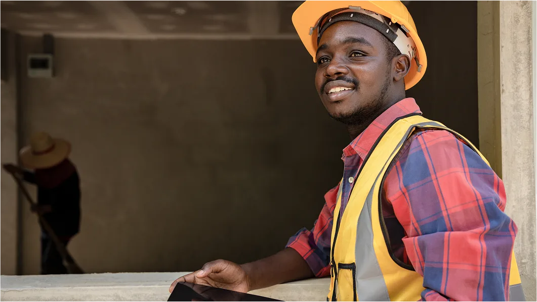 Smiling construction field worker who's happy because all of his HR and payroll needs are being met by modern HR solutions.