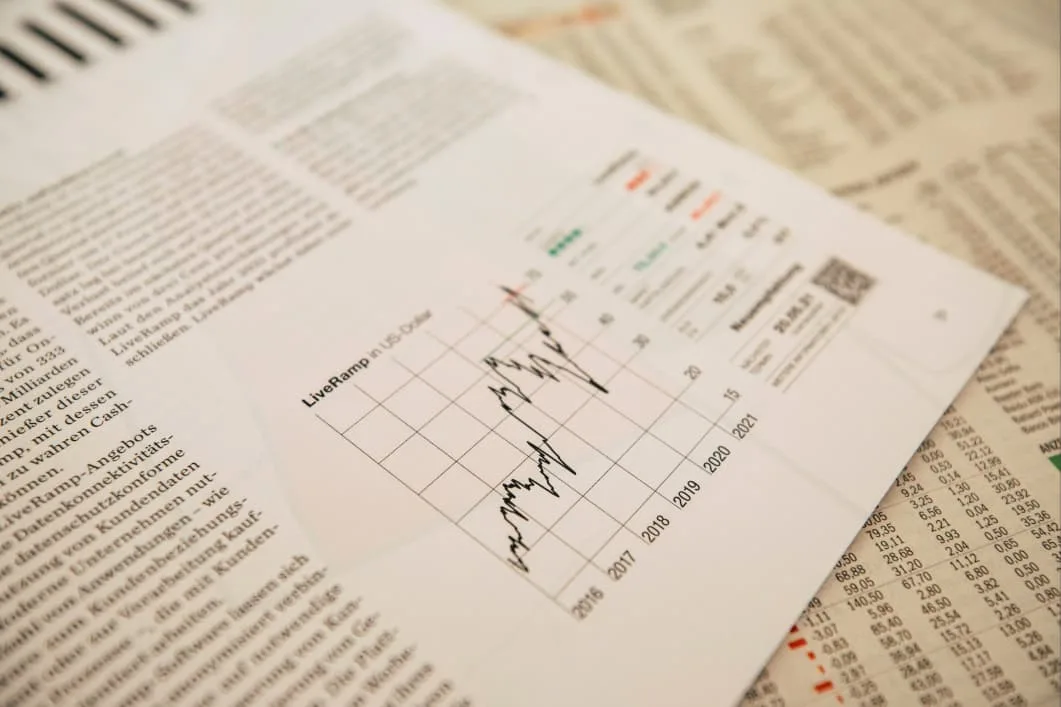 A graph showing fluctuating growth over several years is displayed on a document with financial tables in the background.