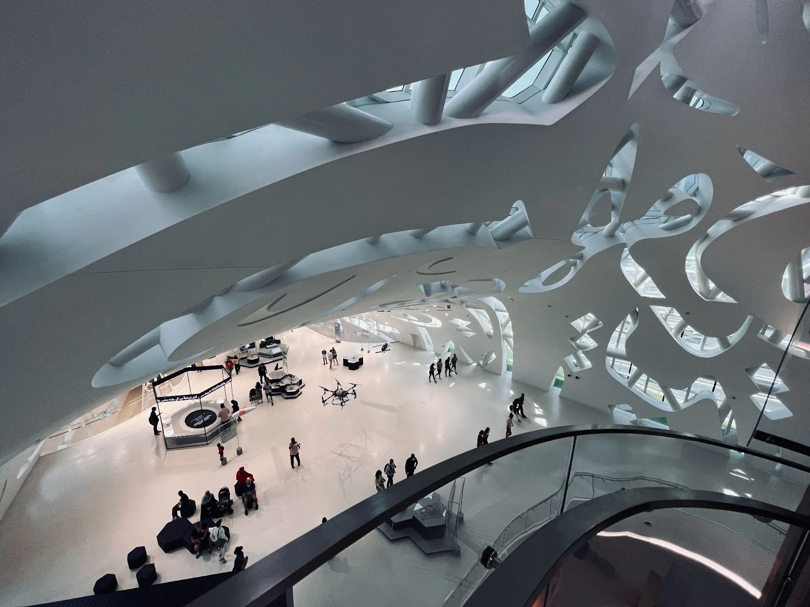 Modern architecture with organic shapes and large open spaces showcasing exhibits and visitors.