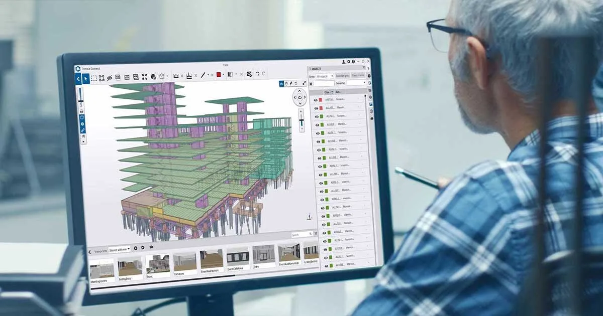 Architect reviewing 3D building model on computer screen.