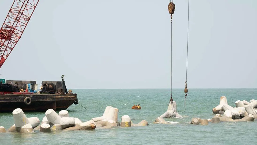 Crane placing tetrapod