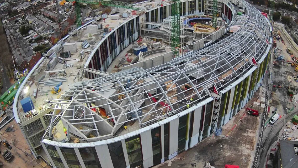 Aerial view of the NH/NCH project under construction in Dublin, showing the building's curved structure and steel framework.