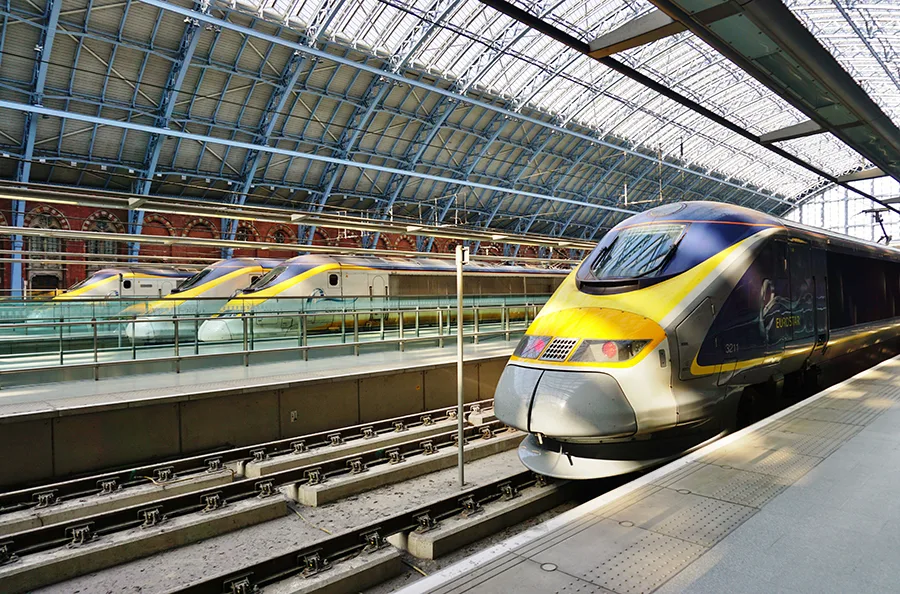 Eurostar trains at St Pancras International station in London under a glass roof.