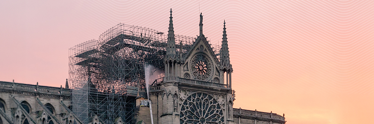 Notre Dame Cathedral under restoration at sunset with scaffolding surrounding the structure