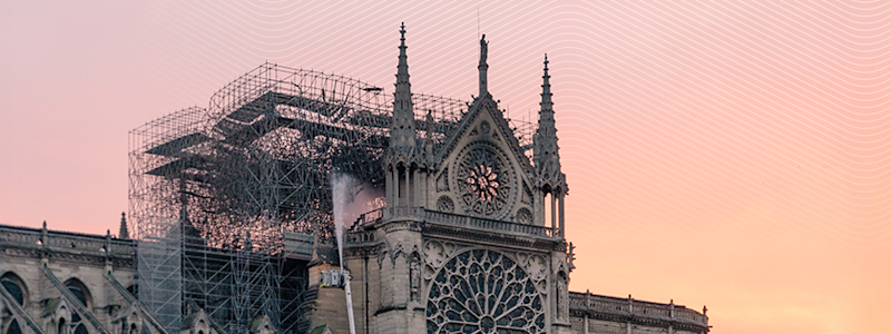 Notre Dame Cathedral under restoration at sunset with scaffolding surrounding the structure