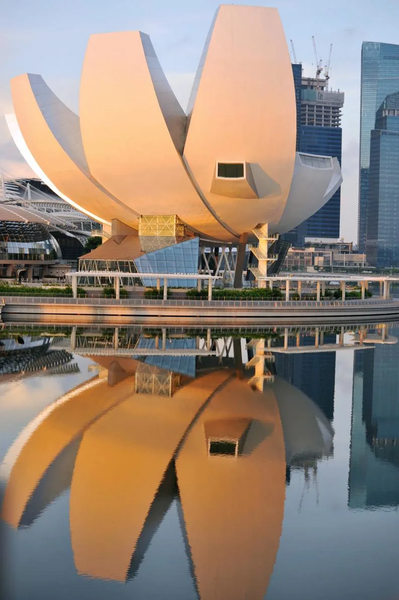 The ArtScience Museum in Singapore, shaped like a lotus flower, is reflected in the calm water.