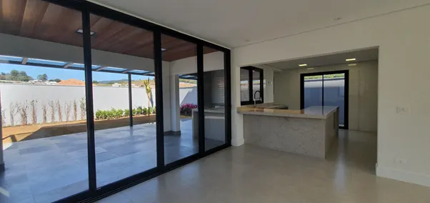 Modern open-plan living area with large glass sliding doors opening to an outdoor patio and a sleek kitchen island with a stone countertop.