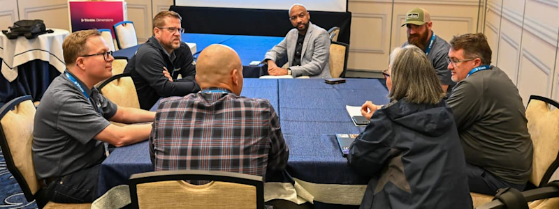 Seven construction contractors seated around a table discussing technology at the 2025 Trimble Dimensions user conference.