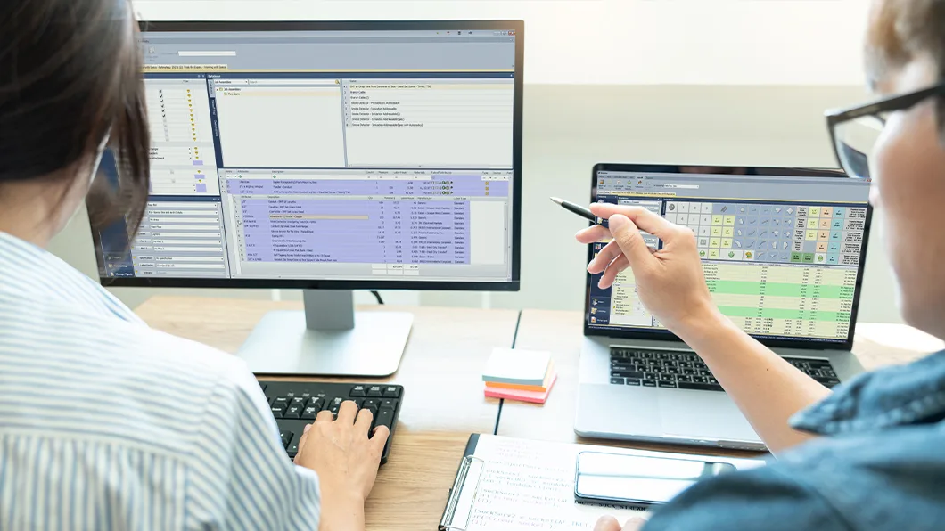 Professionals using Trimble MEP estimating software on dual monitors in an office setting.