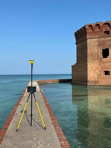 Survey pole with fort and clear water in background