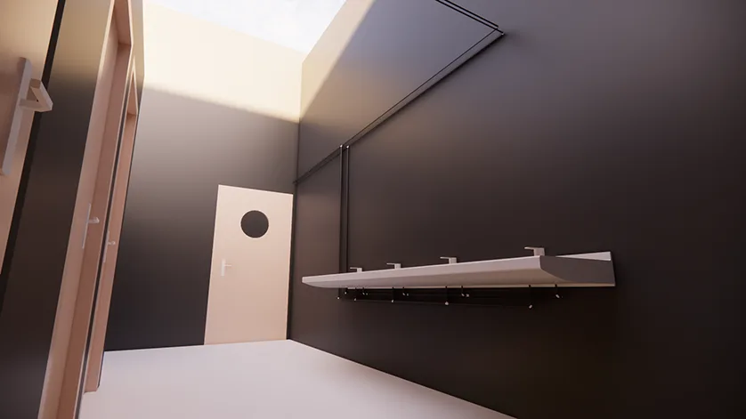 A row of sinks is mounted on a dark wall, with a light-colored door with a circular window in the background.