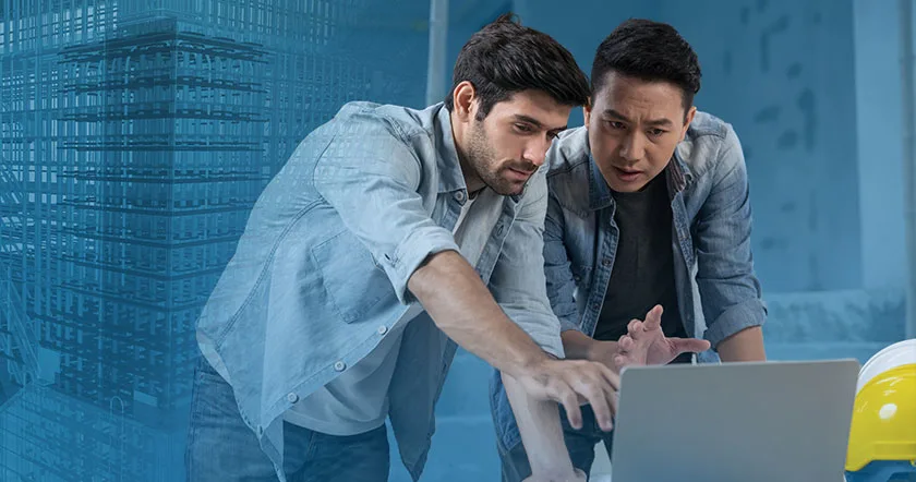 Two construction professionals look at a laptop screen, with a blue overlay of a building's framework behind them.