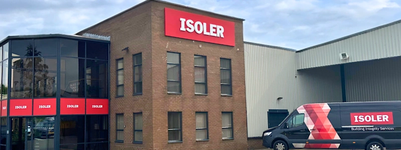 Brick office building with ISOLER signage and branded company van parked outside under cloudy sky.