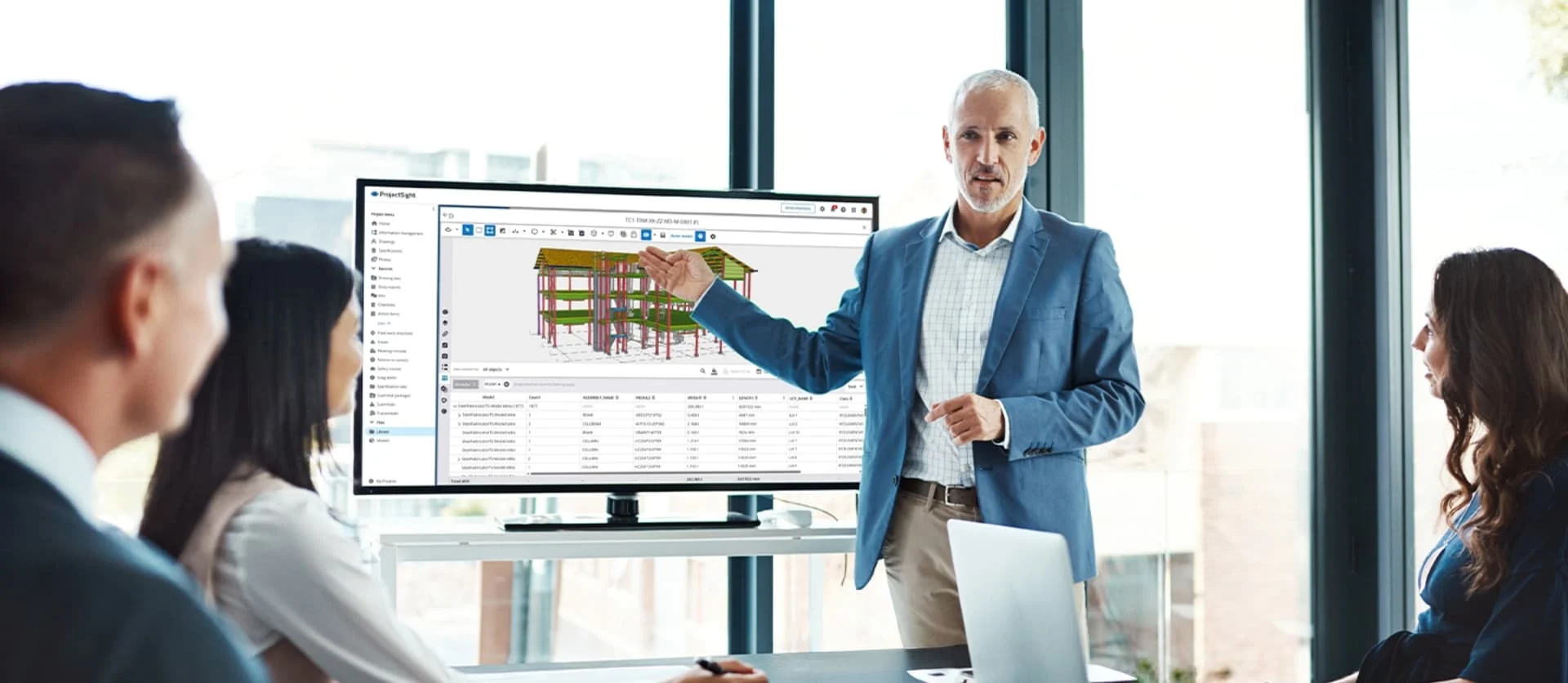 Een presentator wijst naar BIM-gegevens op een monitor tijdens een kantoorvergadering.