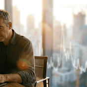Man works on laptop, financial growth chart overlaid on bright city skyline. Suitable for AECO data analysis.
