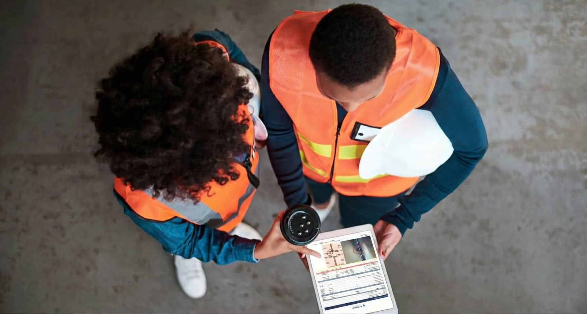 Two workers in safety vests reviewing Viewpoint Field View info on a tablet