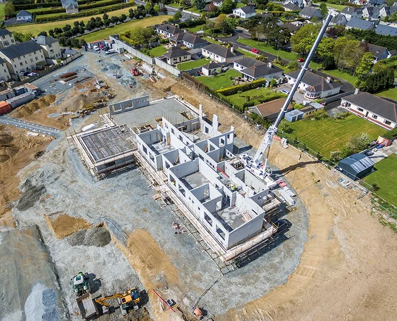 Aerial view of a school construction site in Mallow, County Cork, with concrete walls and a crane visible.
