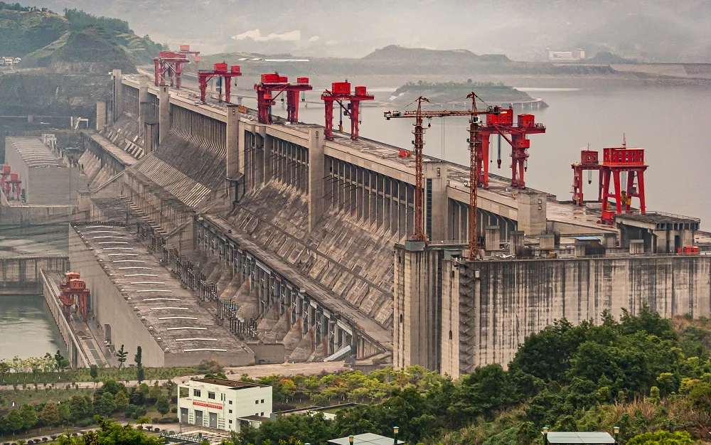The Three Gorges Dam, a massive concrete gravity dam with red cranes visible.