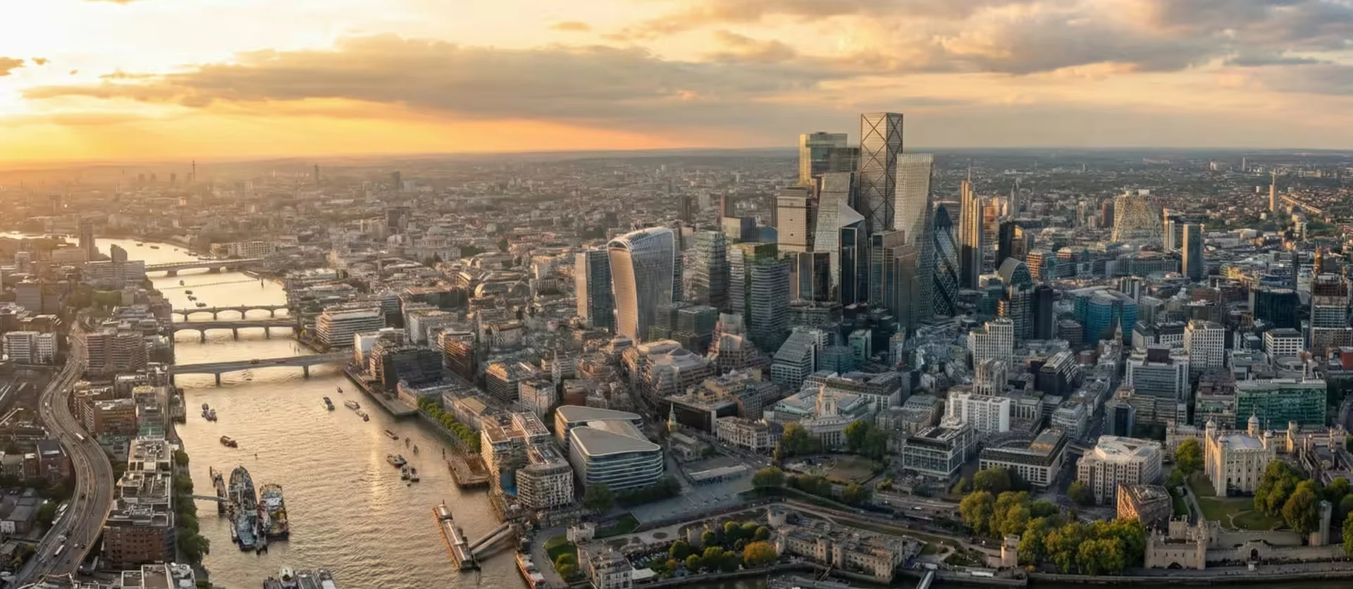 Aerial view of London's skyline and River Thames at sunset.