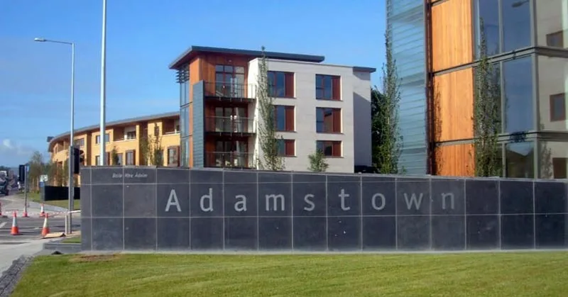 Adamstown sign with modern buildings behind it.