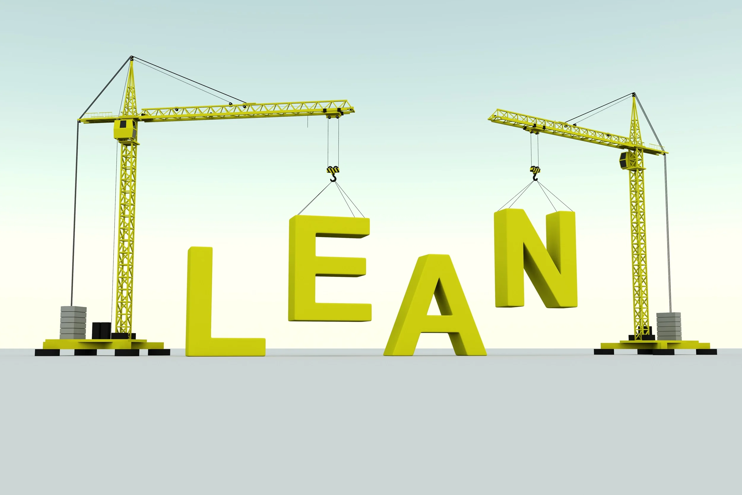 Cranes build the word LEAN out of yellow letters.