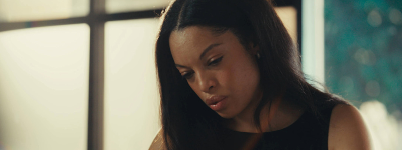 Taryn holds a pen and book in hand at her workspace.