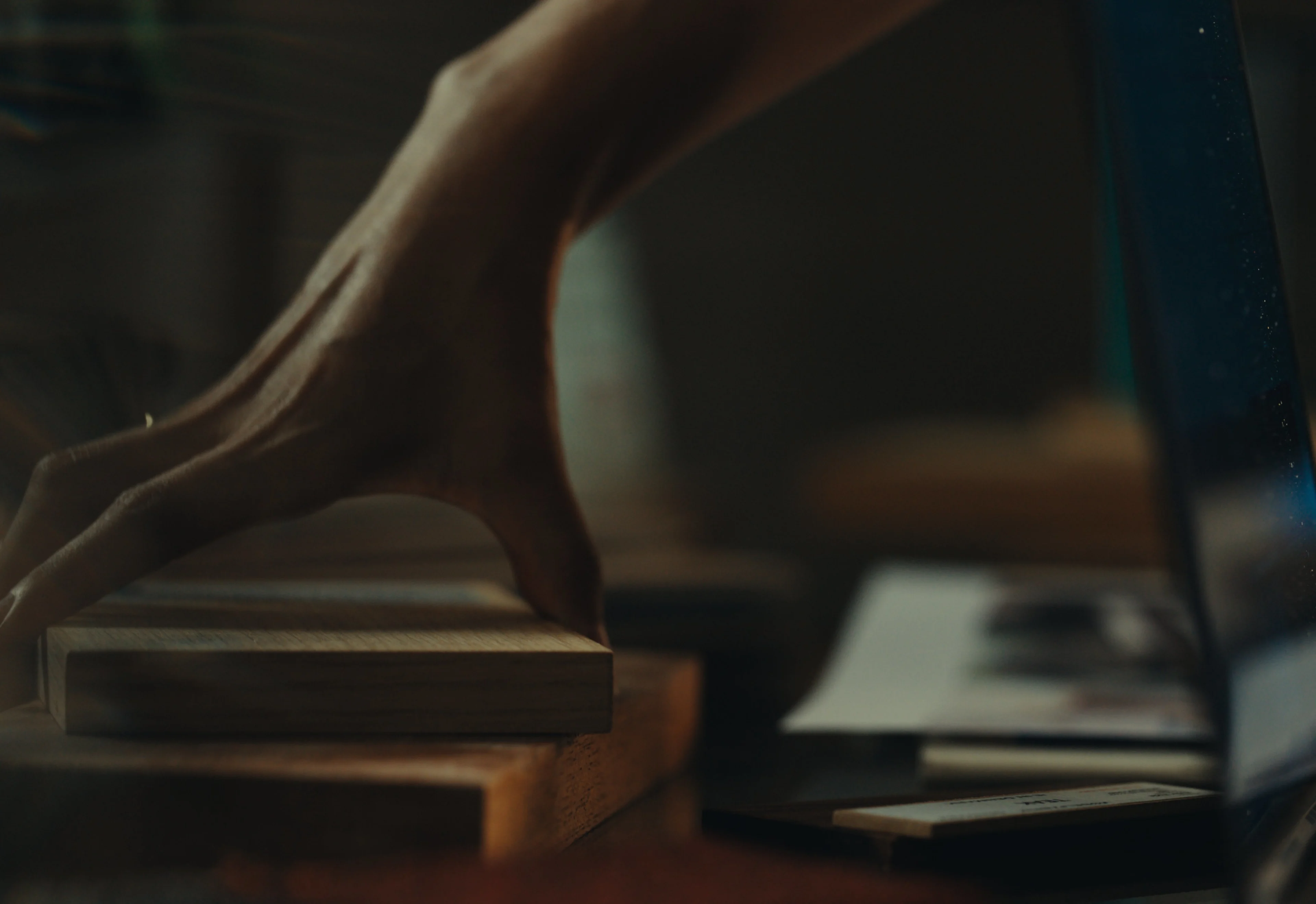 Taryn holds a block of wood in her workspace.