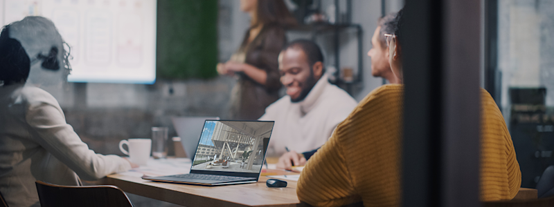 A diverse AEC design team seated around a conference table review a draft 3D model in SketchUp.