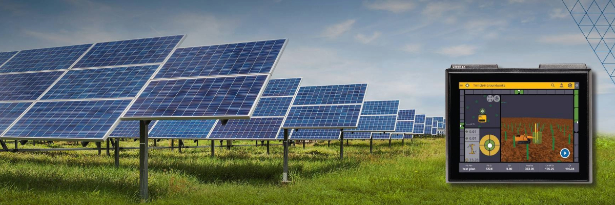 Solar panel farm in a green field under a blue sky, with a Trimble Groundworks display screen overlay showing grading data.