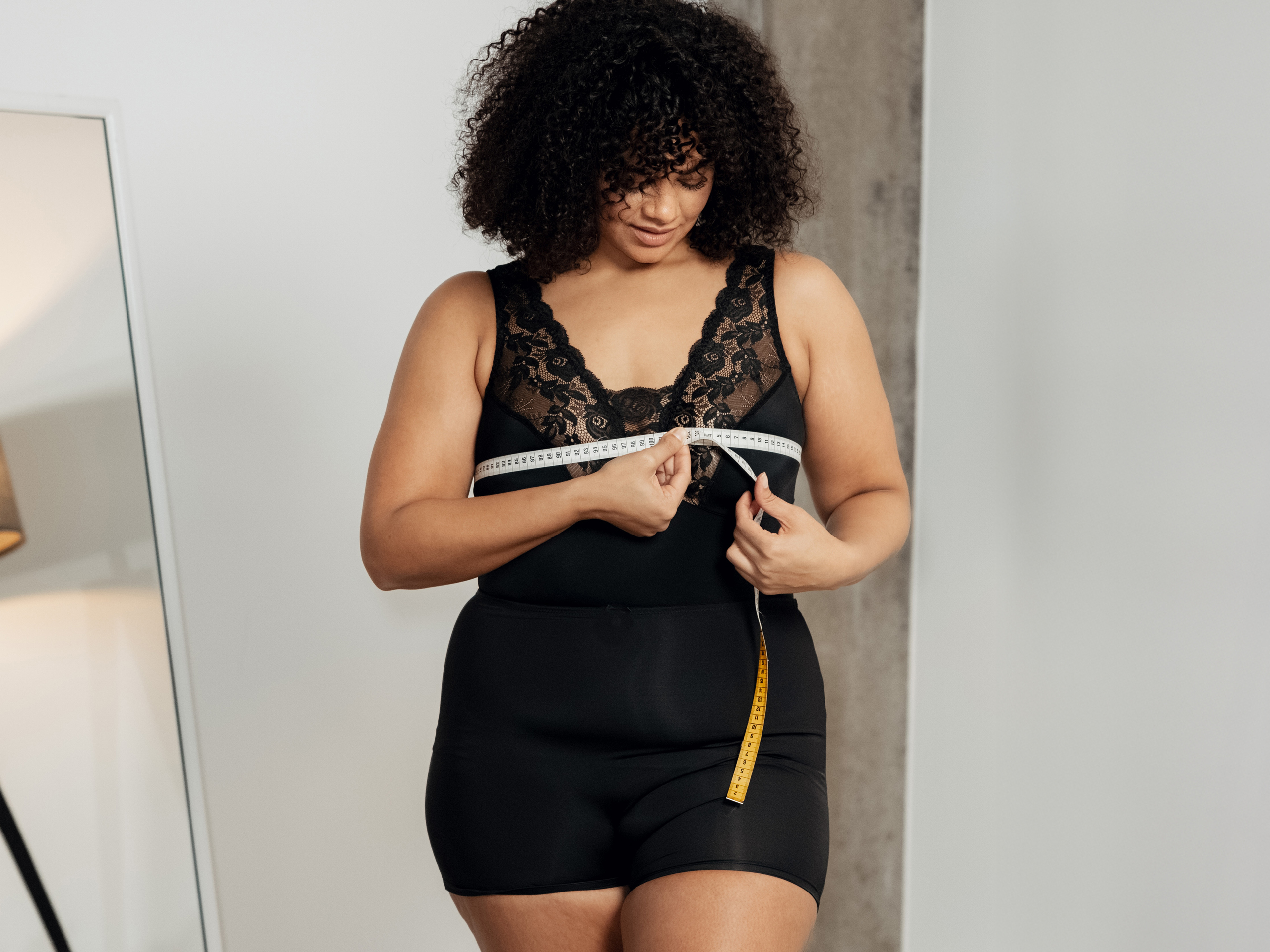 Frau misst sich mit einem Maßband aus