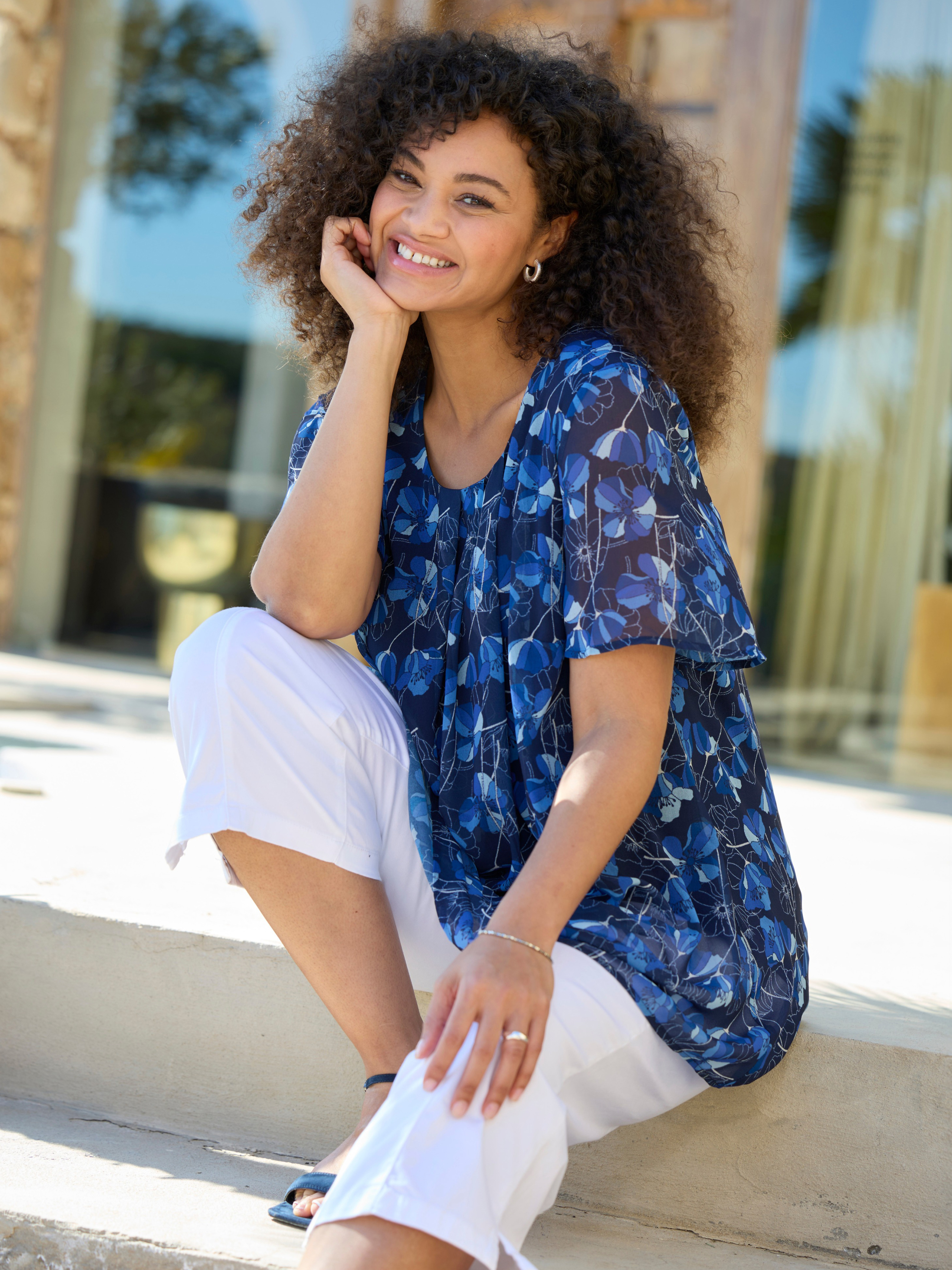 Werbebanner mit Model in blau gemusterter Tunika und weißer Caprihose