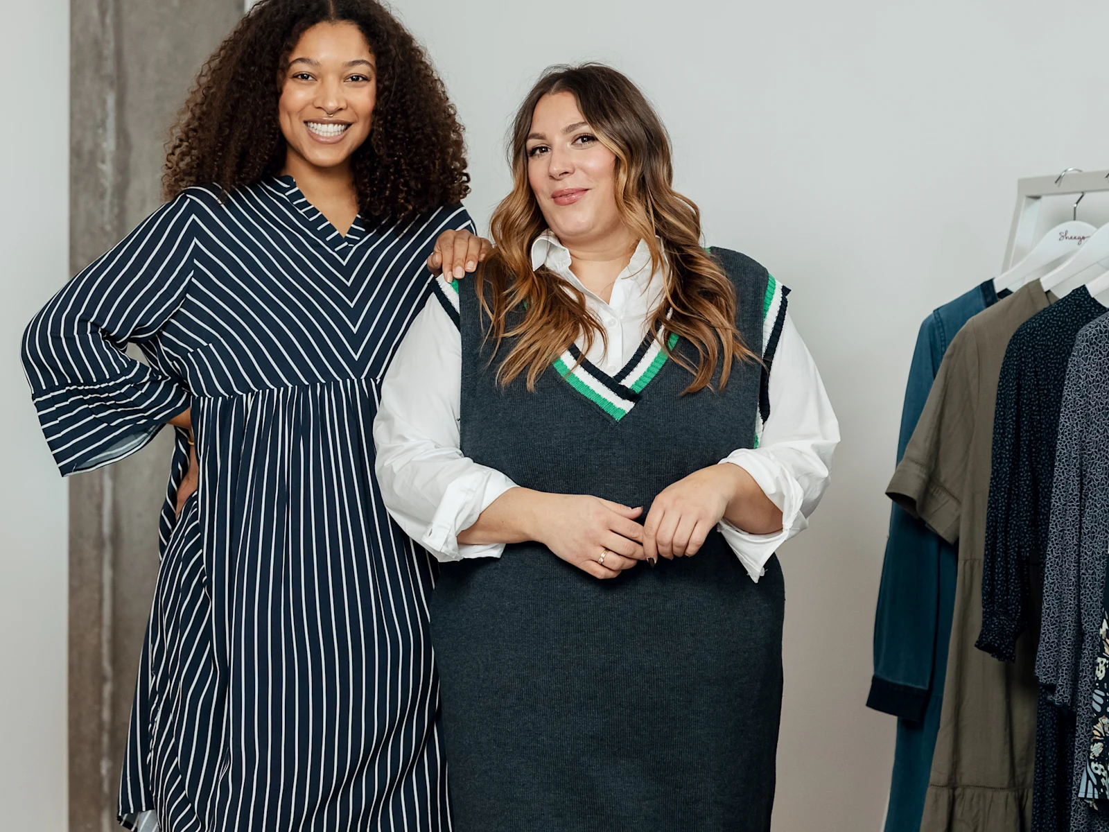 Zwei Frau stehen nebeneinander und lächeln in die Kamera